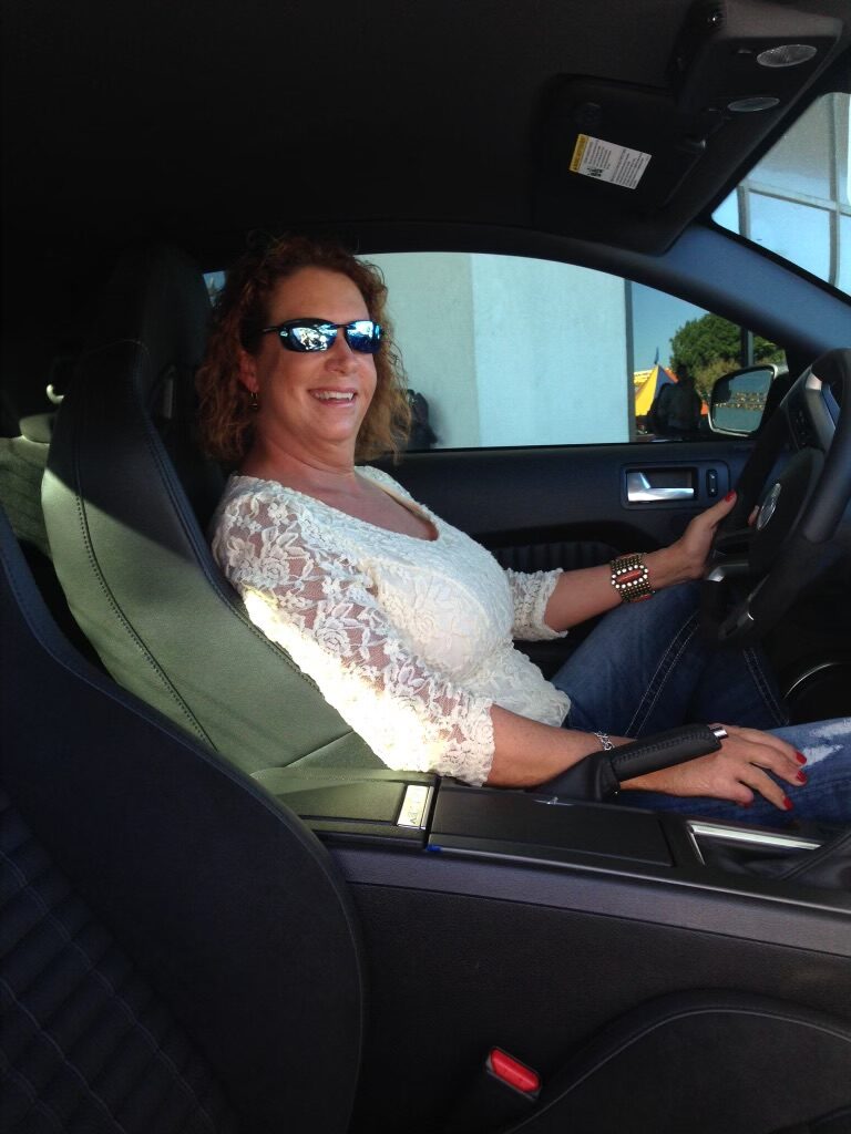 Shelby smiling in the driver seat of her car