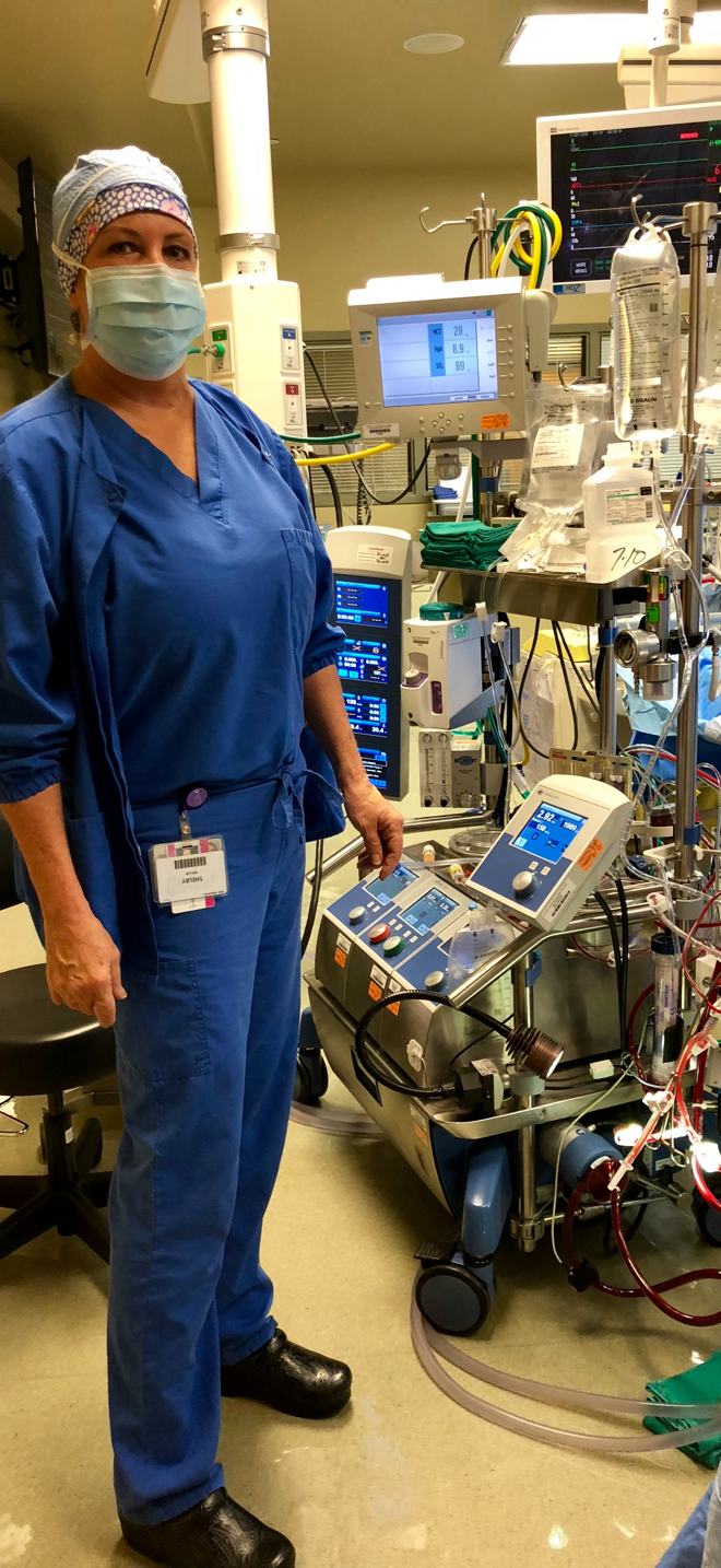 Shelby Maverick Miller beside cardiovascular perfusion equipment in a clinical setting